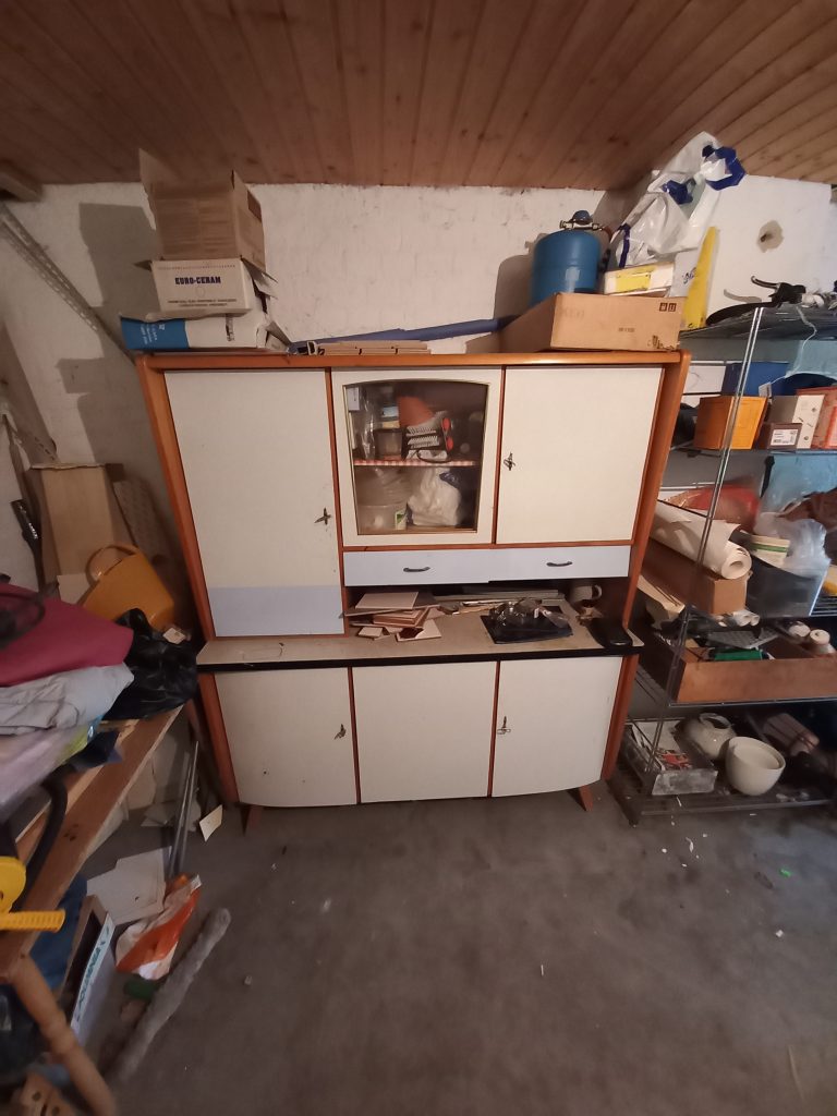 Ein alter Schrank in einem Keller, der vor einem Umzug entsorgt werden soll Ein alter Schrank in einem Keller, der vor einem Umzug entsorgt werden soll